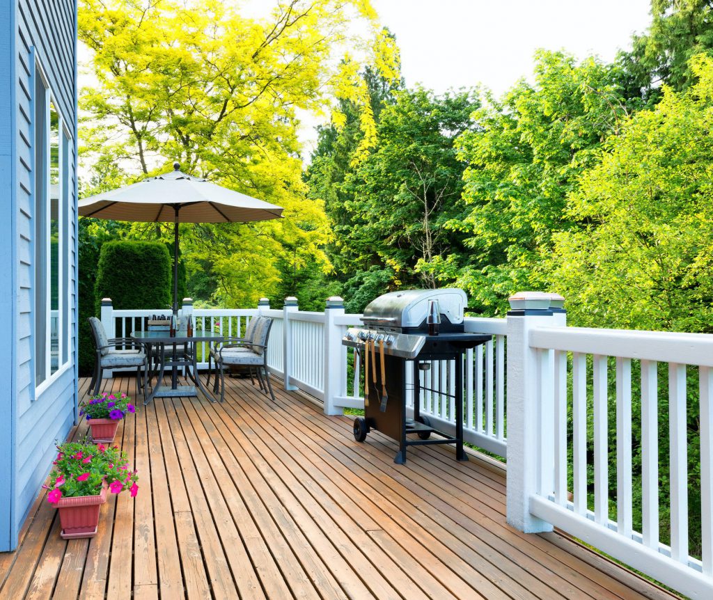A professional staining a deck railing and boards