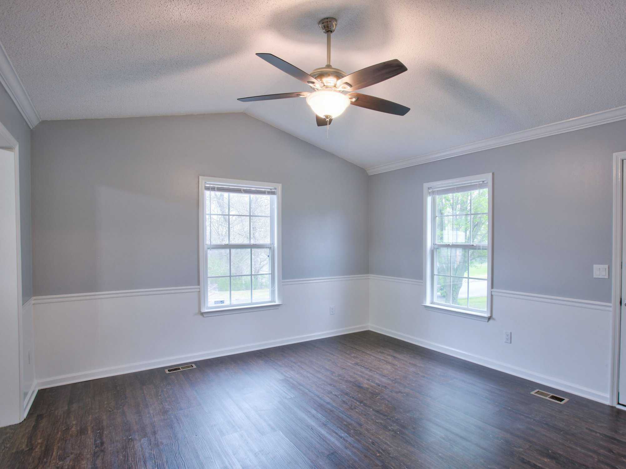 Gray living room interior with vaulted ceilings and chair rail. Interior house painting safety