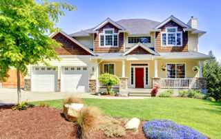 Large American beautiful house with red door and two white garage doors. exterior paint maintenance tips